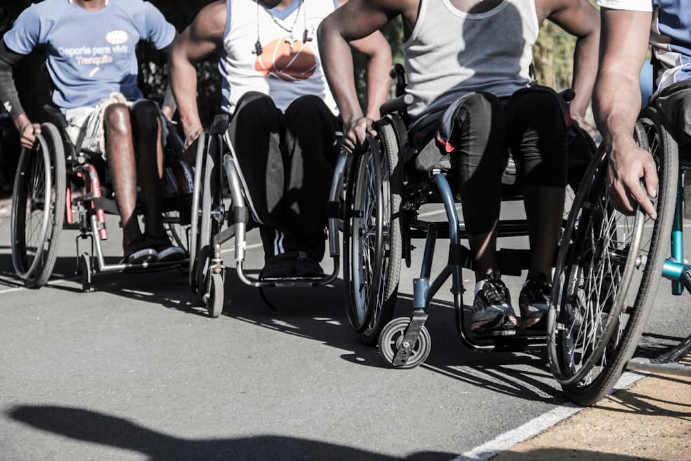 A group of wheelchair basketball players in action on an outdoor court.